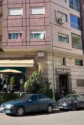 two cars parked in front of a building at حي الشرف in Marrakech