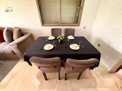 a dining room table with a black table cloth and chairs at Appartement Prestigia Agate résidence avec piscine in Marrakech