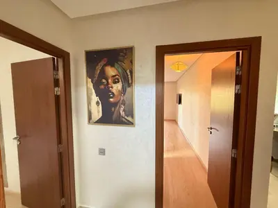 a hallway with a painting of a woman on the wall at Appartement Prestigia Agate résidence avec piscine in Marrakech