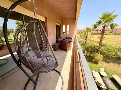 a hanging porch swing on a balcony with a patio at Appartement Prestigia Agate résidence avec piscine in Marrakech