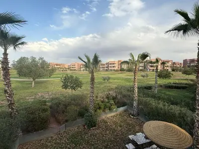 a view of a resort with palm trees and buildings at Appartement Prestigia Agate résidence avec piscine in Marrakech