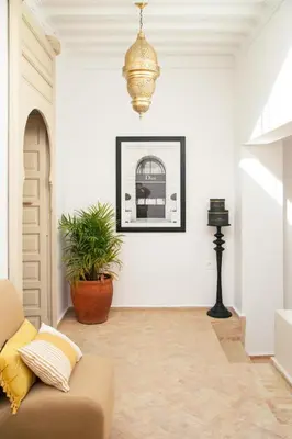 a living room with a couch and a chandelier at Riad À l'ombre des Orangers in Marrakech