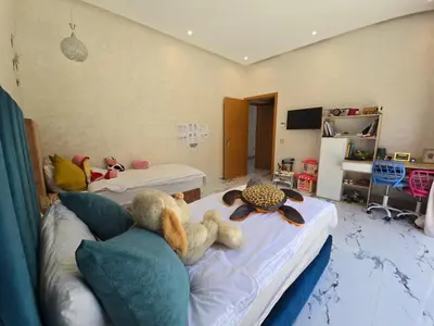 two stuffed animals laying on a bed in a room at Villa echwitter in Marrakech