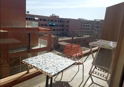 a table and chair on a balcony with a view at Skyline Studios Hivernage in Marrakech