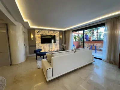 a living room with a couch and a fireplace at Yves Saint Laurent Jacuzzi Elegance in Marrakech