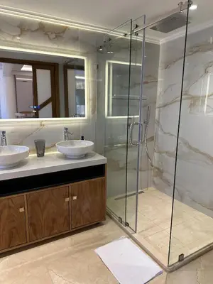 a bathroom with two sinks and a glass shower at Yves Saint Laurent Jacuzzi Elegance in Marrakech