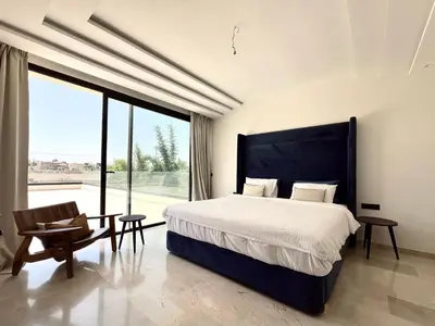 a bedroom with a large bed and a large window at villa éden marrakech in Oulad Ikhia