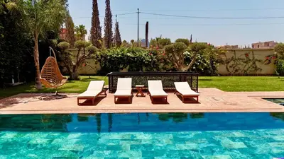 a pool with lounge chairs and a table and chairs at villa éden marrakech in Oulad Ikhia