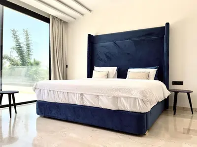 a bedroom with a large bed with a large blue headboard at villa éden marrakech in Oulad Ikhia