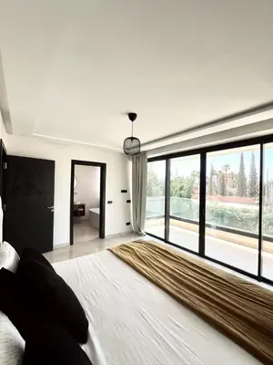 a bedroom with a large bed with a large window at villa éden marrakech in Oulad Ikhia