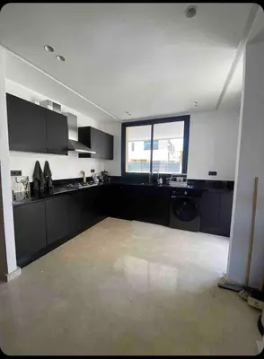 a large kitchen with black cabinets and a window at Villa in Urban Morocco, Marrakech in Marrakech