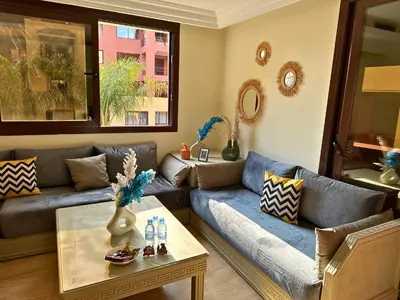 a living room with a couch and a table at Somptueux Appartement avec Jacuzzi Privé Marrakech in Marrakech