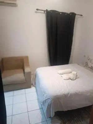 a bedroom with a bed and a chair in it at big house with swiming pool in Marrakech
