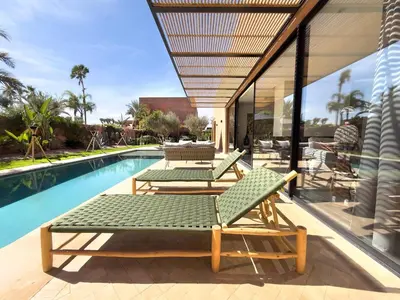a patio with two lounge chairs and a swimming pool at Villa à Marrakech 8 Personnes, Piscine et Petits-Déjeuners Inclus in Sraghna