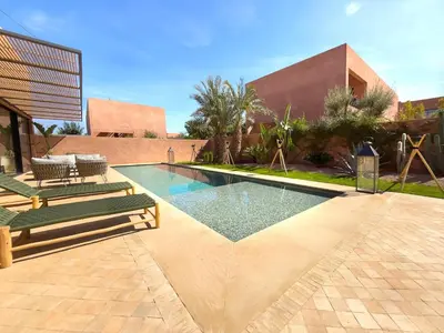 a swimming pool in the middle of a courtyard with a building at Villa à Marrakech 8 Personnes, Piscine et Petits-Déjeuners Inclus in Sraghna