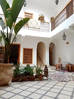 a large room with potted plants and stairs at Quite riad in Marrakech