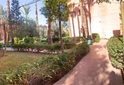 a walkway in front of a building with trees at Maison Mariam in Marrakech
