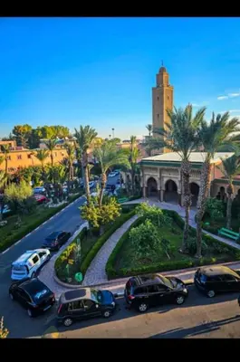 a group of cars parked on a street with a building at Maison Mariam in Marrakech