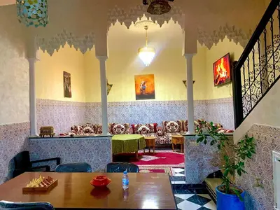 a restaurant with a table and chairs in a room at Maison Mariam in Marrakech