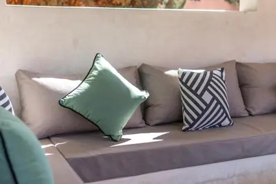 a couch with three pillows sitting on it at Villa Anna - Havre de paix in Oulad Ikhia