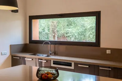 a kitchen with a sink and a large window at Villa Anna - Havre de paix in Oulad Ikhia