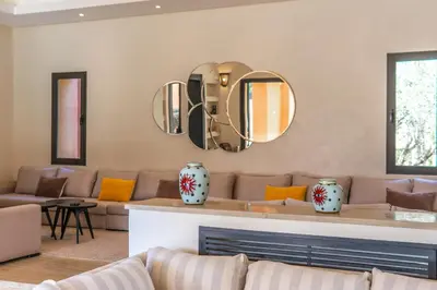 a living room with a couch and mirrors on the wall at Villa Anna - Havre de paix in Oulad Ikhia