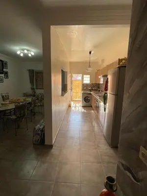 a kitchen and dining room with a table and a refrigerator at Dar SAÏDA in Marrakech