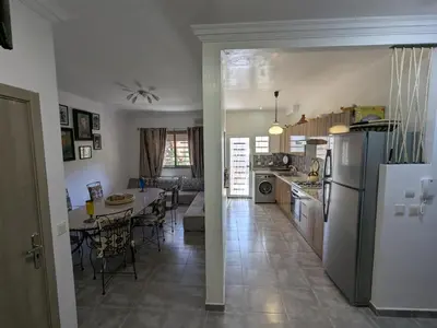 a kitchen and living room with a table and a refrigerator at Dar SAÏDA in Marrakech