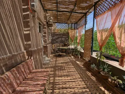 an outdoor porch with benches and a table and windows at Dar SAÏDA in Marrakech