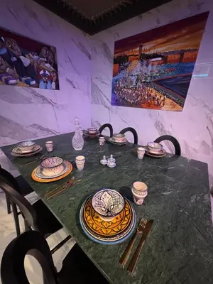 a table with plates and bowls on top of it at Beautiful new modern house with full comfort in Marrakech