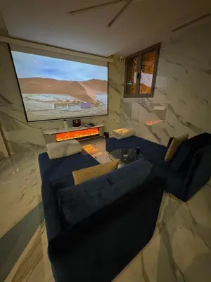 a living room with a blue couch and a flat screen tv at Beautiful new modern house with full comfort in Marrakech