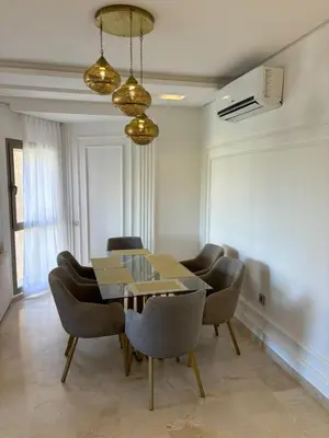 a dining room with a table and chairs at Beautiful residence with pools inMarrakech Golf City in Marrakech