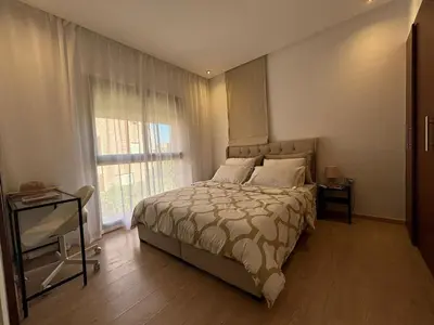 a bedroom with a large bed and a window at Beautiful residence with pools inMarrakech Golf City in Marrakech