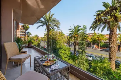 a table with food on a balcony with palm trees at Luxury 1 BDR Hivernage in Marrakech