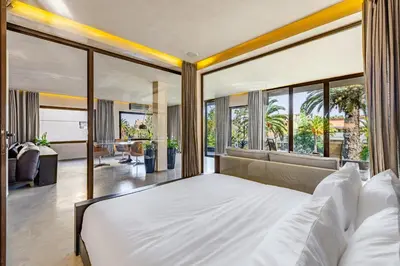 a bedroom with a large bed and a living room at Luxury 1 BDR Hivernage in Marrakech