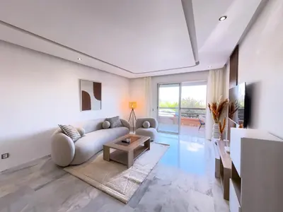 a living room with a couch and a table at Charme Appt En Résidence Riad Garden Avec Piscine in Marrakech