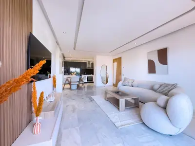 a living room with a couch and a table at Charme Appt En Résidence Riad Garden Avec Piscine in Marrakech