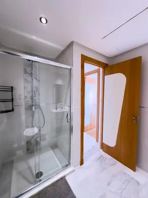 a bathroom with a shower and a glass shower stall at Charme Appt En Résidence Riad Garden Avec Piscine in Marrakech