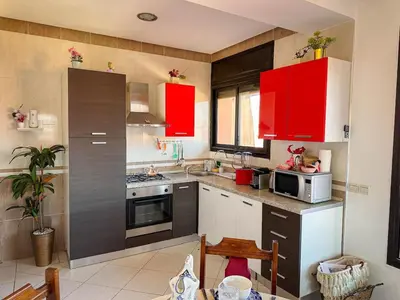 a kitchen with red cabinets and a stove top oven at Amazing Apartment Center city in Marrakech