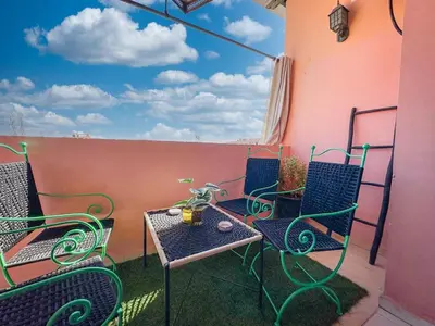 a patio with chairs and a table on a balcony at Amazing Apartment Center city in Marrakech