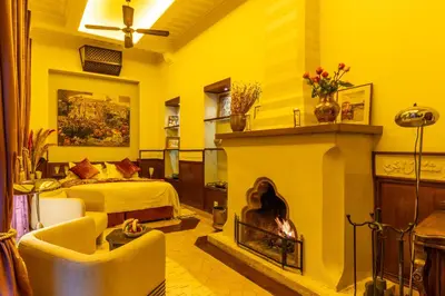 a living room with a fireplace and a bed at Riad Habouba in Marrakech
