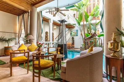 a living room with a pool and a table and chairs at Riad Habouba in Marrakech