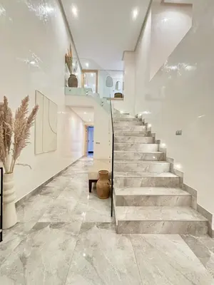 a staircase in a home with white walls and stone floors at Luxueux DUPLEX au cœur Marrakech in Marrakech