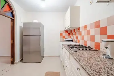 a kitchen with a stove and a refrigerator at Golden Palm 2 in Marrakech