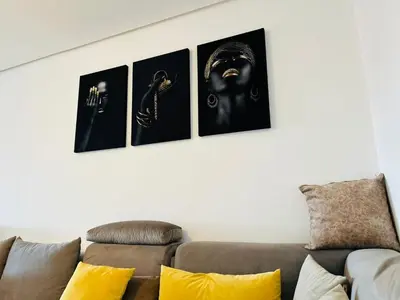 a row of four pictures on a wall above a couch at Atrani1 happy holiday in Marrakech