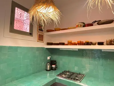 a kitchen with a stove and a green tile counter top at Dar Nook in Marrakech