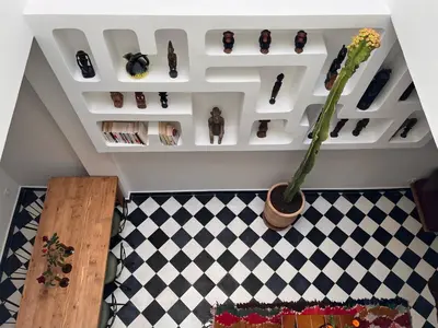 a room with a shelf with shoes and a vase with a plant at Dar Nook in Marrakech