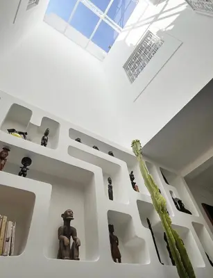 a living room with white walls and a skylight at Dar Nook in Marrakech