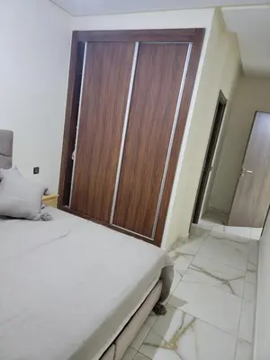 a bedroom with a large wooden door in a room at Magnifique appartement sur Marrakech in Marrakech