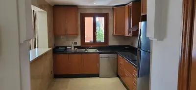 a kitchen with wooden cabinets and a sink and a window at La Plaza cœur de Gueliz in Marrakech